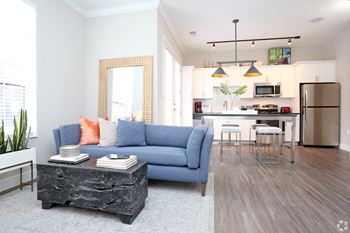a living room and kitchen with a blue couch and a table at Century Baxter Avenue, Louisville Kentucky